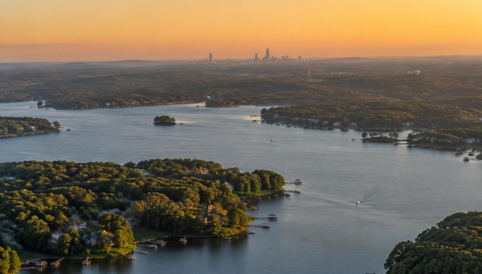 Aerial view of Lake Wylie at golden hour with the Charlotte skyline on the far horizon